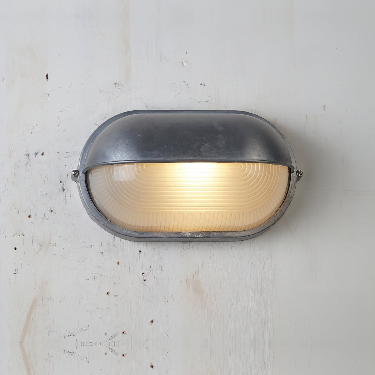 Outdoor Bulkhead Wall Light with Oval Shield and Ribbed Glass Diffuser
