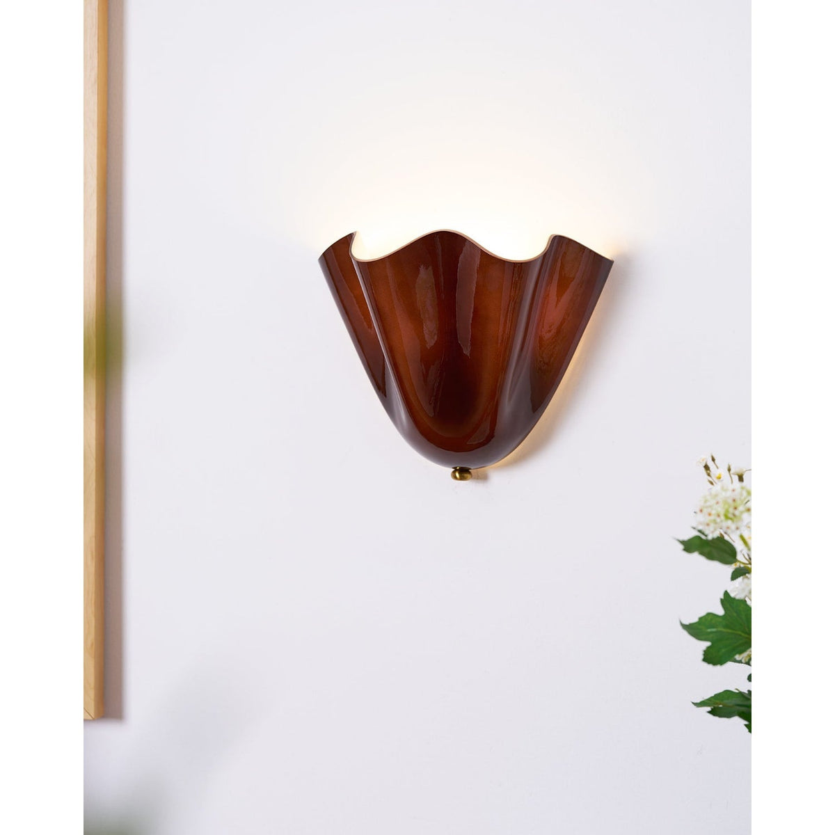 Wall Sconce with Wavy Glass Shade and Warm Ambient Lighting