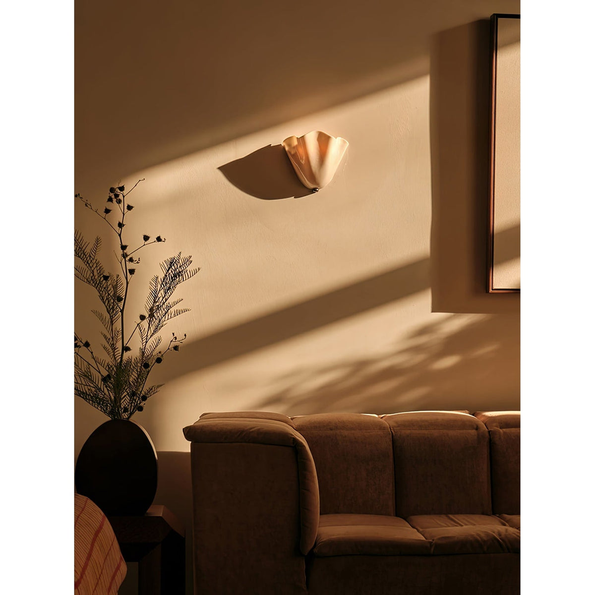 Wall Sconce with Wavy Glass Shade and Warm Ambient Lighting