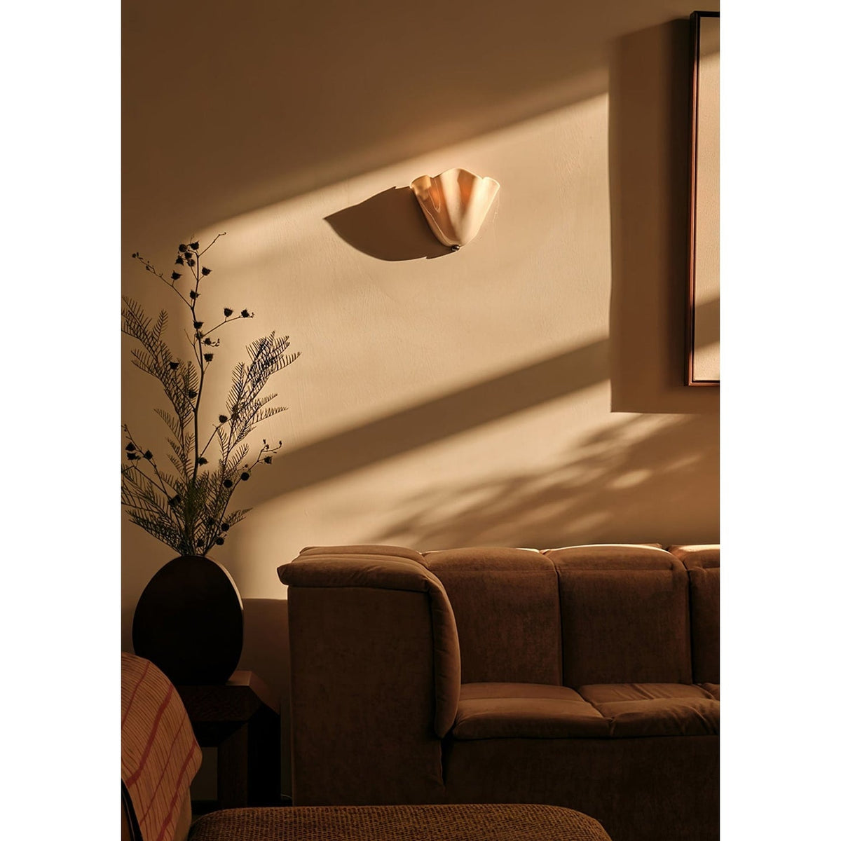 Wall Sconce with Wavy Glass Shade and Warm Ambient Lighting