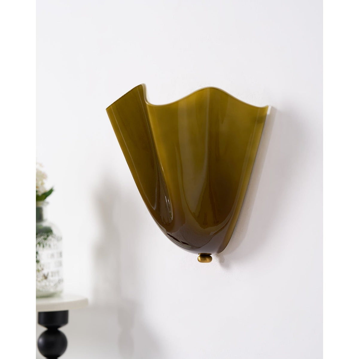 Wall Sconce with Wavy Glass Shade and Warm Ambient Lighting