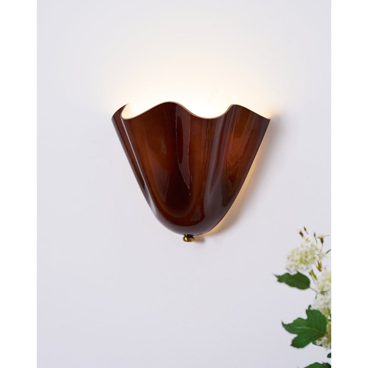 Wall Sconce with Wavy Glass Shade and Warm Ambient Lighting