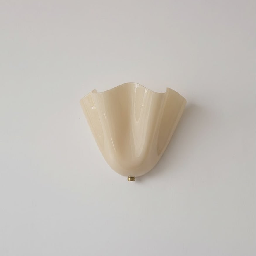 Wall Sconce with Wavy Glass Shade and Warm Ambient Lighting