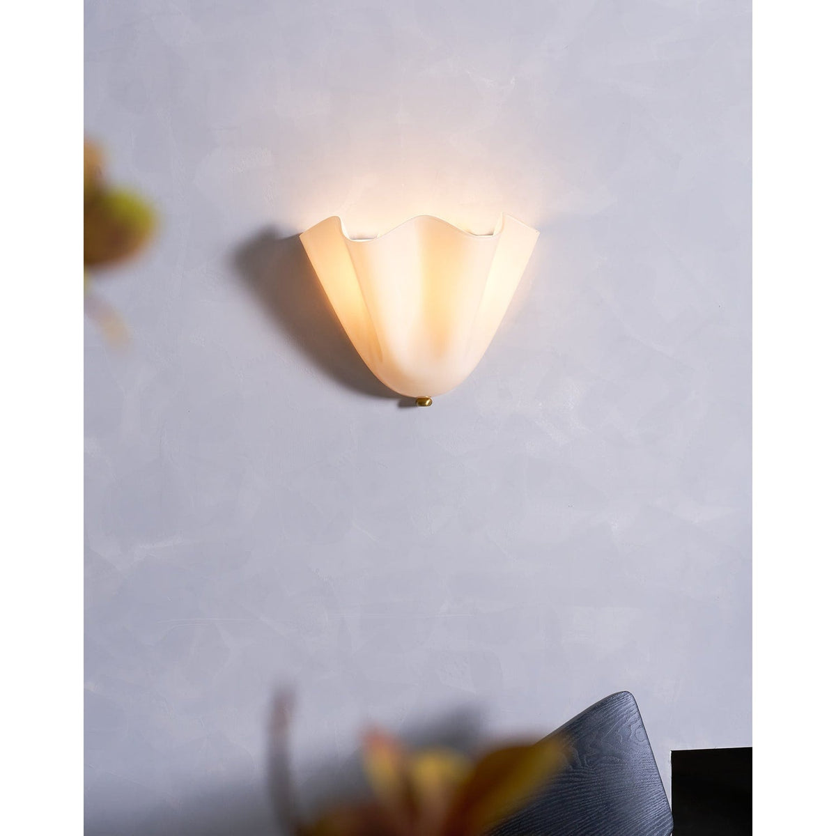 Wall Sconce with Wavy Glass Shade and Warm Ambient Lighting