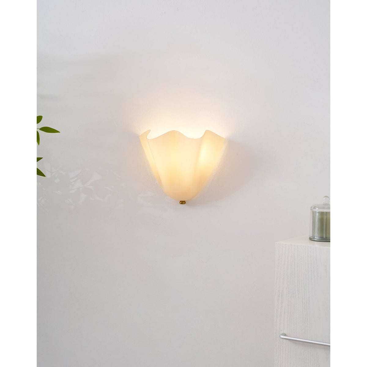 Wall Sconce with Wavy Glass Shade and Warm Ambient Lighting
