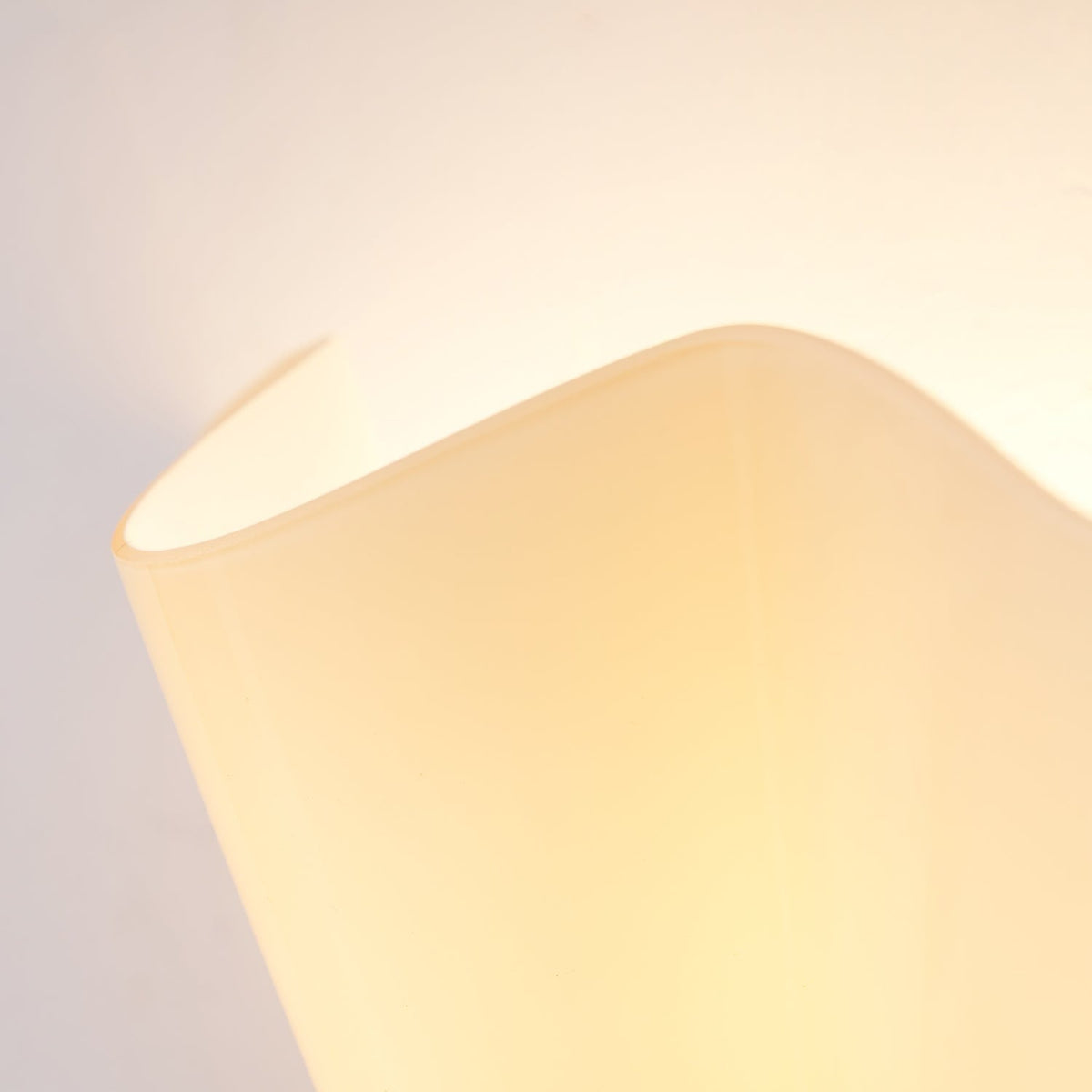 Wall Sconce with Wavy Glass Shade and Warm Ambient Lighting