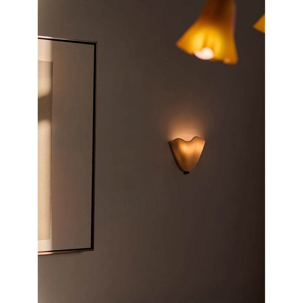 Wall Sconce with Wavy Glass Shade and Warm Ambient Lighting